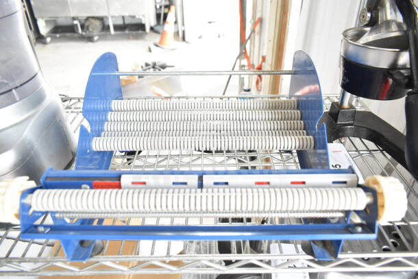 Uline Cutter with blue frame, mounted on a wire shelf. Features multiple cutting rollers, suitable for industrial use.