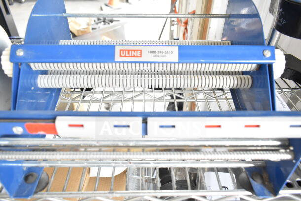 Uline cutter with blue frame and coiled rollers, in good condition. Uline label with contact info on top.