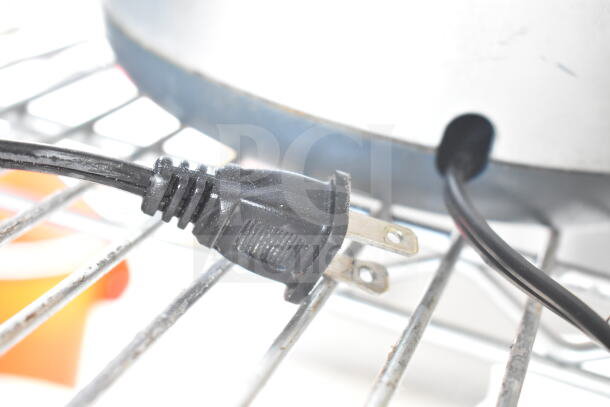 Cuisinart FP-8 Food Processor power cord on metal grate, detail of 120V plug.