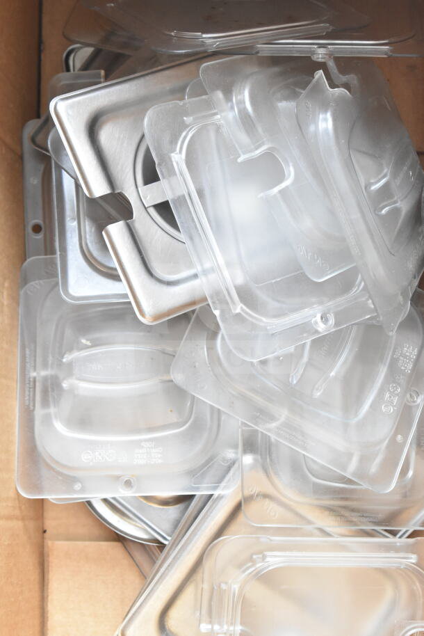 Assorted drop-in bin lids in various sizes, plastic and metal, stacked in a box. Both new and used condition.