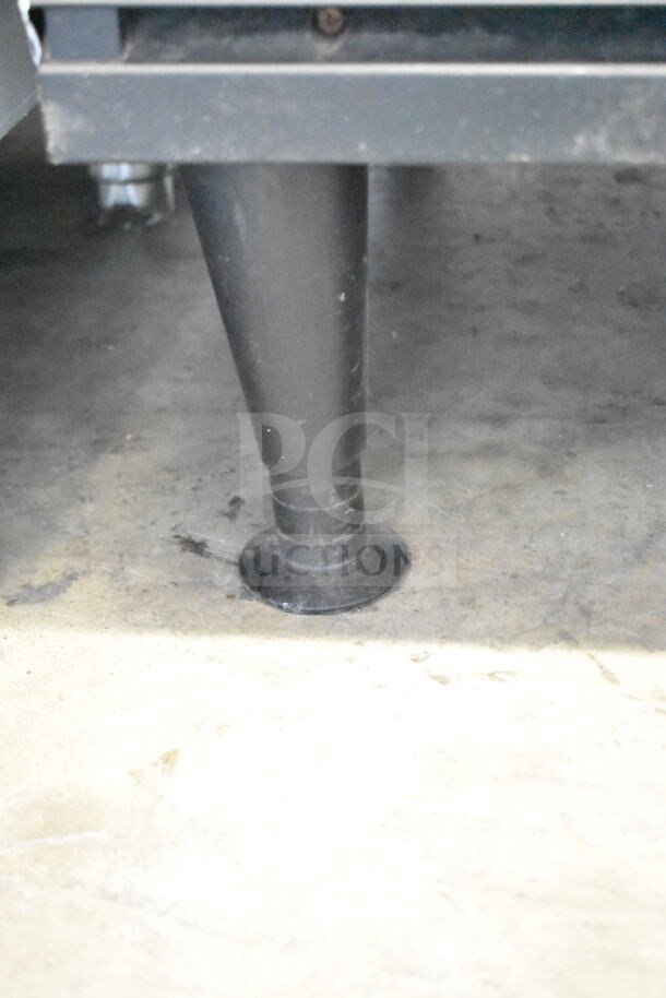 Close-up of Ice-O-Matic ICEU220HA3 ice machine leg, showing sturdy construction and condition on concrete floor.