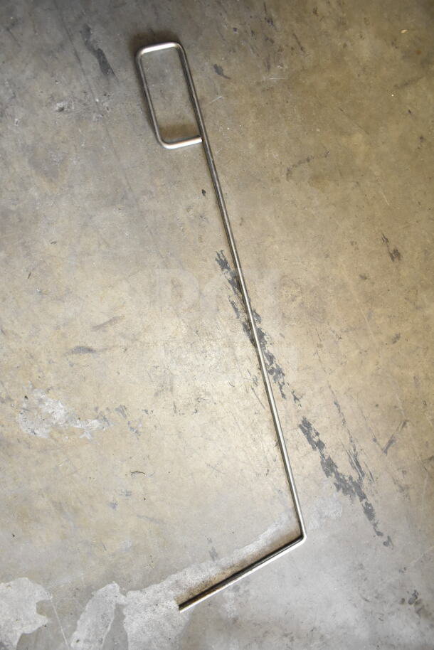 Metal rod on concrete floor; appears to be a component or accessory, possibly used with commercial kitchen equipment.