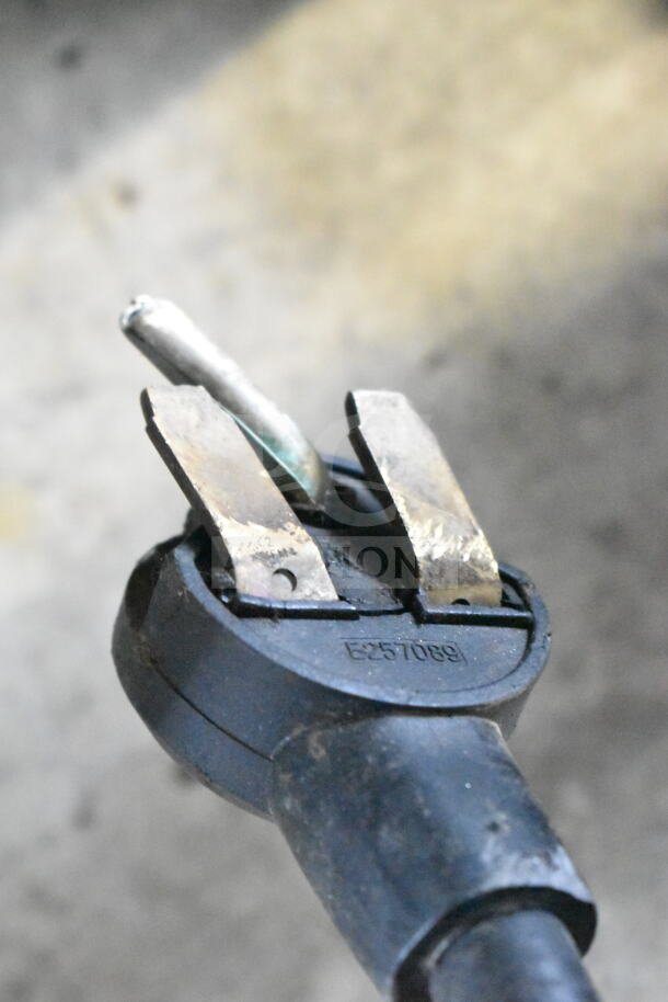 Close-up of a power plug for a Turbochef NGC Rapid Cook Oven, showing worn prongs and the marking "E257089."