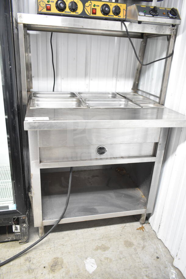 Commercial electric powered steam table with sneeze guard, 120/208 volts, 1 phase. Stainless steel construction, three-pan capacity.
