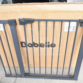 Babelio Baby Gate, black metal, features secure latch, new condition, includes original packaging with visible brand name.