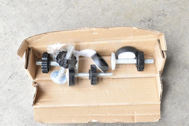 Babelio Baby Gate parts, including screws and adjusters, in an open cardboard box. Appears new, with bagged components.
