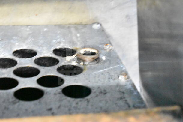 Radiance Commercial Gas 2 Burner Range, metal surface with ventilation holes, showing signs of wear.