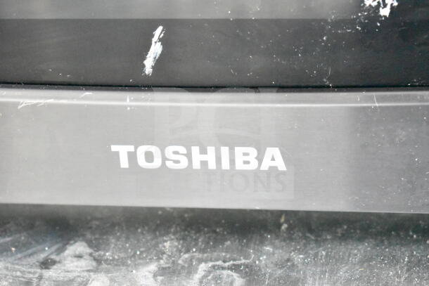 2024 Toshiba EM131A5C-BS commercial countertop microwave. Visible wear on silver finish. 120 volts, 1 phase.