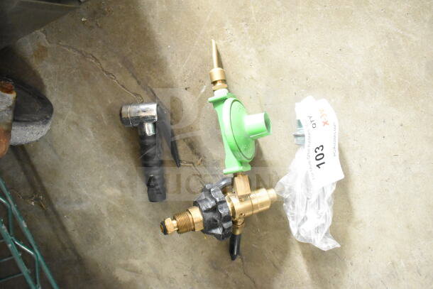 Three various tools on concrete, including a green gas regulator, with auction tag labeled 103. Items in used condition.