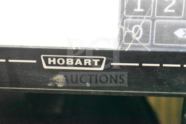 2017 Hobart HTi-7LH26 commercial scale, visible screen damage, missing power cord. Model label "Hobart" shown.