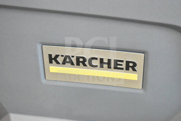 Karcher logo on gray surface of the KM 85/50 R BP ride-on sweeper.