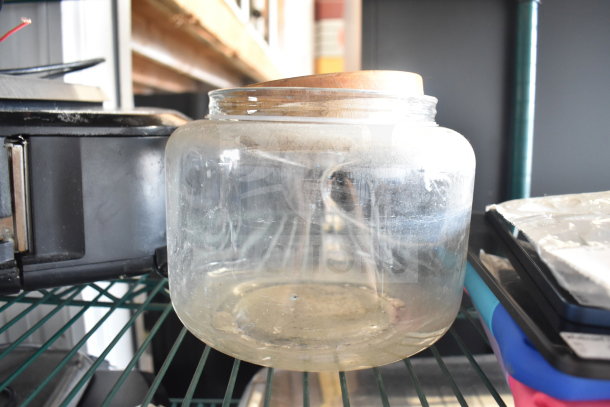 Clear glass jar with wooden lid on shelf, part of auction lot with Taylor thermometers and other items. Mixed condition.