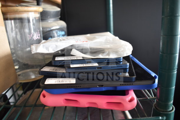 Seven various Onn tablets stacked, featuring visible USB ports. Some tablets have protective cases. Tags read "Walmart".