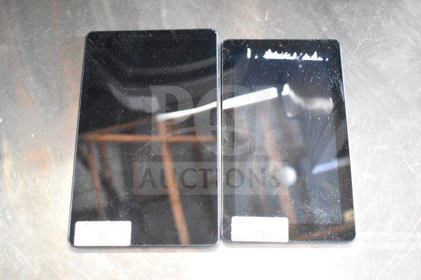 Seven various Onn tablets displayed on a reflective surface, used condition. Some have visible screens without cracks, markings on screens indicate model numbers.