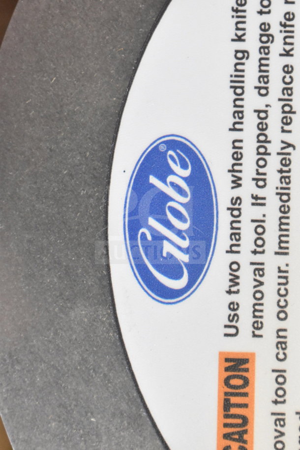Alt text: Globe meat slicer blade remover with caution label.