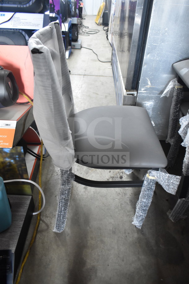 5 new Lancaster Table & Seating ladder back chairs with 2.5" dark gray vinyl padded seats. Metal frame, scratch and dent.