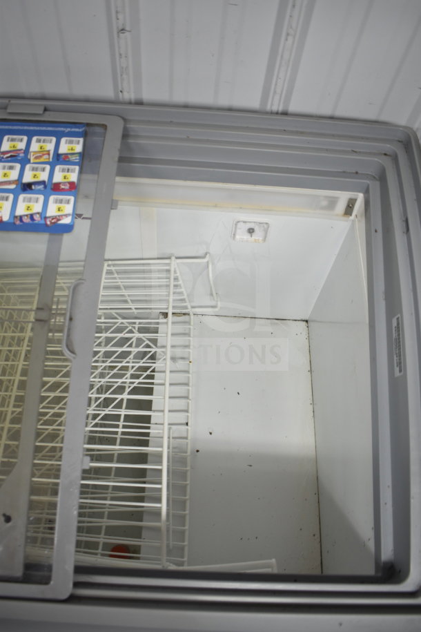Commercial Freezer Merchandiser, 115V, 1 Phase, white wire shelving, glass sliding lid, interior shows usage marks.