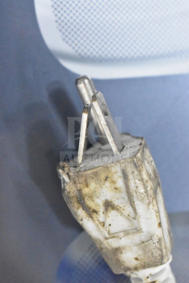 Close-up of a worn power plug from the H01GN001 washing machine, showing rust and dirt on the prongs and casing.