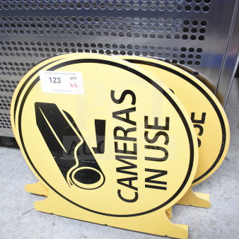 Three yellow "Cameras In Use" signs with black camera graphic. Includes auction label: Lot 123, quantity 3.