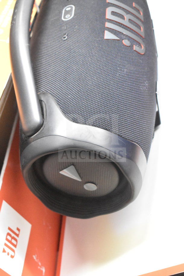 JBL Boombox speaker on display, featuring a durable black mesh design and logo. Includes original packaging.