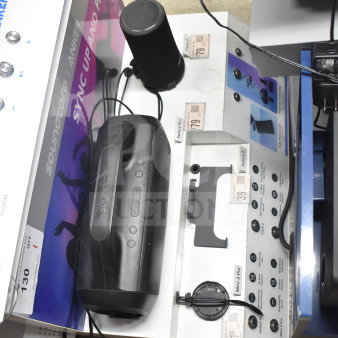 Store display featuring Soundcore Anker Select Pro speaker, showcasing controls and charging setup. Includes marketing graphics.