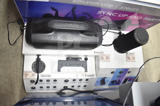 Store display with Soundcore Anker speakers, including Select Pro and Mini 3 Pro models. Prices and features indicated.
