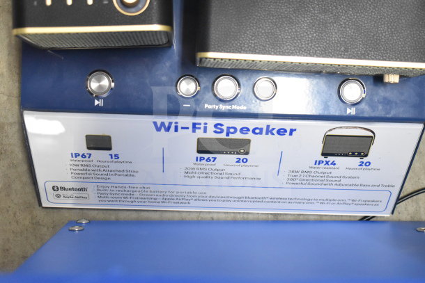 Store display featuring Wi-Fi speaker specifications: IP67 waterproof, 20W RMS output, 20 hrs playtime, multi-directional sound.