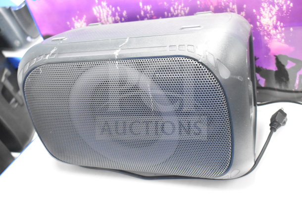 Onn Medium Party Speaker, store display with visible wear, power cord attached, gridded front panel, scratch marks.