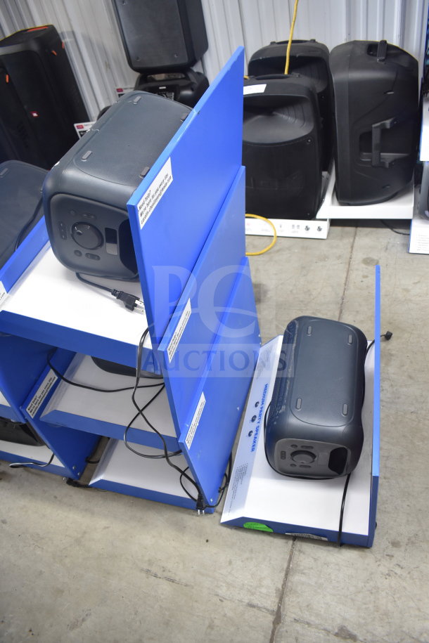 4 store display featuring Onn medium party speakers, black, good condition, with visible cords and display tags.