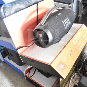 JBL Boombox 3 speaker on store display, features large handle, black mesh exterior, visible JBL branding and function buttons.
