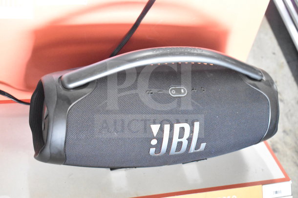 JBL Boombox 3 speaker on store display, featuring a sleek black design, large handle, and prominent JBL logo.