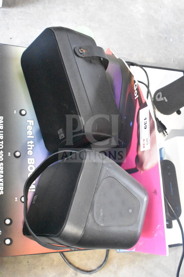 Store display featuring Altec Lansing speaker and Soundcore speaker, both in good condition, with original packaging.