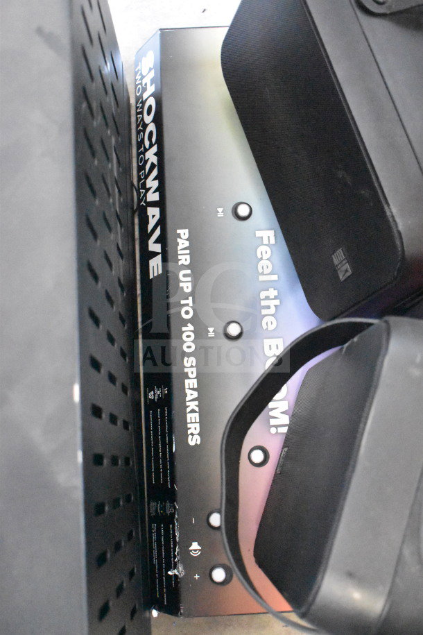Store display featuring Altec Lansing and Soundcore speakers, marked "Shockwave" with features like pairing up to 100 speakers.