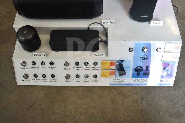 Store display with JBL Boombox 3 and Soundcore speakers. Features include immersive sound, waterproof design, and 20-hour playtime.