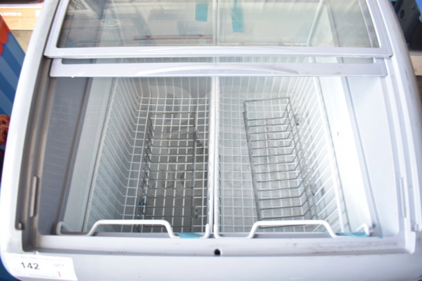 Commercial chest freezer merchandiser, 115 volts, 1 phase, with sliding glass top, metal baskets, excellent condition.