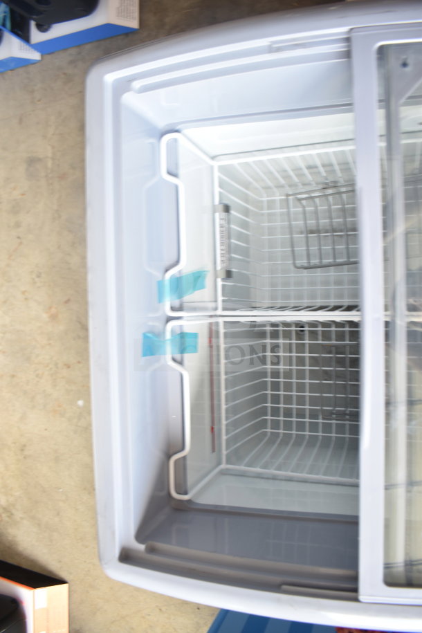 Commercial chest freezer merchandiser, 115 volts, 1 phase, with glass sliding doors and wire baskets inside.