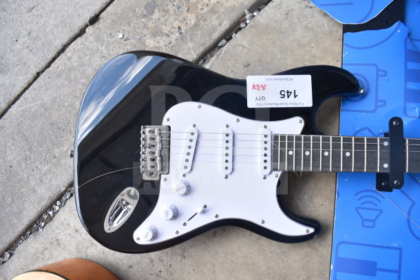 Black and white Rock Jam electric guitar, Stratocaster style, with three pickups, tremolo bridge, and auction tag labeled 145.