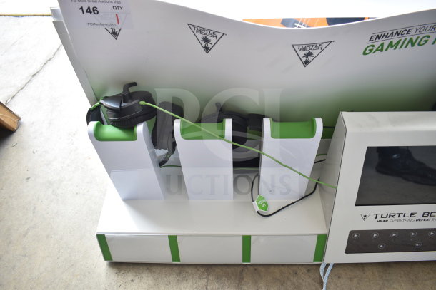 Turtle Beach store display with headphones, featuring brand logos and a digital screen, in good condition.