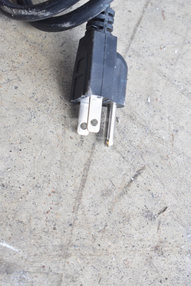 Power plug with a black cord on a textured surface.