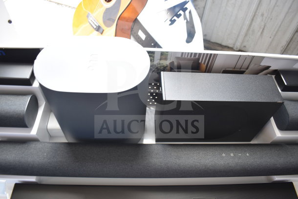 Store display with multiple speakers and a soundbar, featuring modern design and sleek finishes.