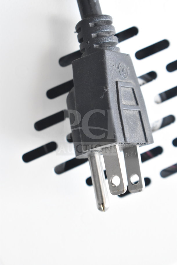 Close-up of a black power plug inserted into a slotted white surface, part of the PS5 Outform UE200205-C commercial display.