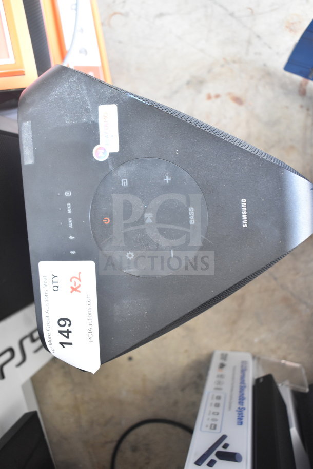 Samsung MX-ST4CB speaker, top view with controls, brand logo, and auction tag "Qty x2". Slight surface dust visible.