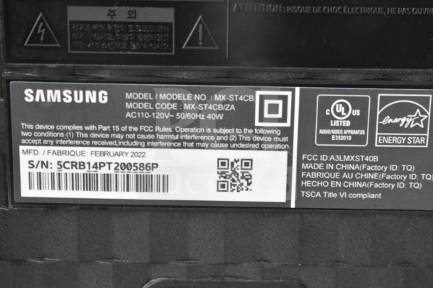 Samsung MX-ST4CB speaker label showing model number, FCC compliance, Energy Star logo, and serial number.