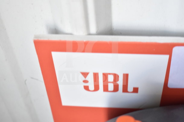 JBL logo on a store display featuring the JBL Partybox 110 speaker. Image shows a close-up of the logo on the display board.