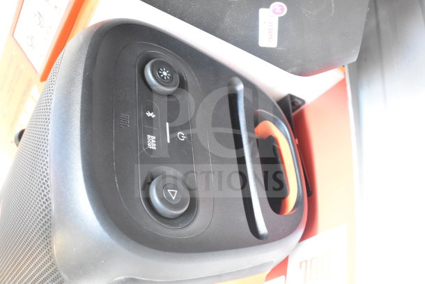 JBL Partybox 110 speaker display, highlighting control panel with bass boost, Bluetooth, and power buttons. Auction includes two units.