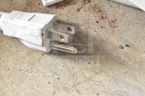 Ion Party Boom Plus Speaker power plug, slightly worn, lying on a concrete surface.