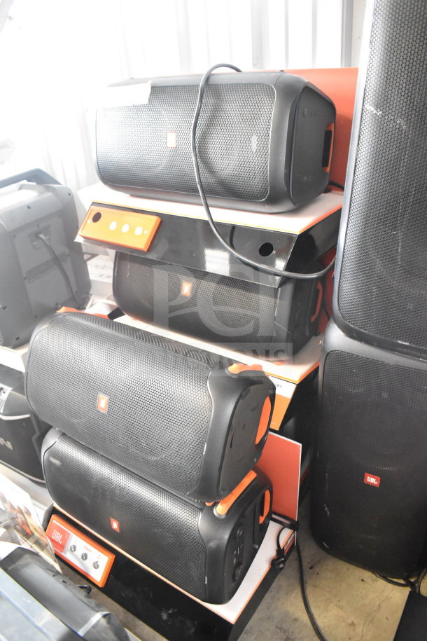 JBL speaker display, five units stacked; black with orange trim. JBL logos visible. Auction item, condition appears used.