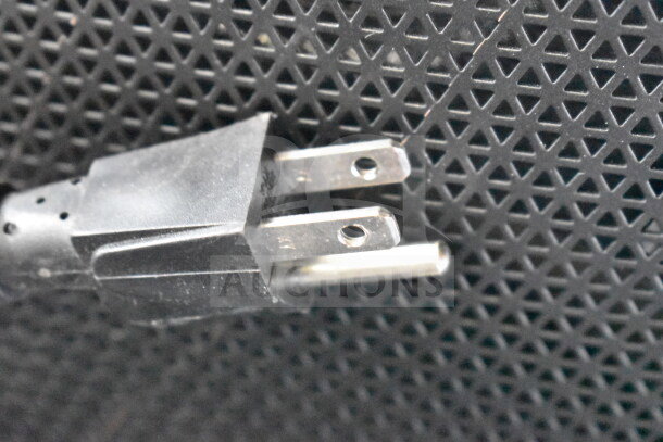 Power plug detail on JBL Partybox 310 speaker, featuring a textured grille. Ideal for store display setup.