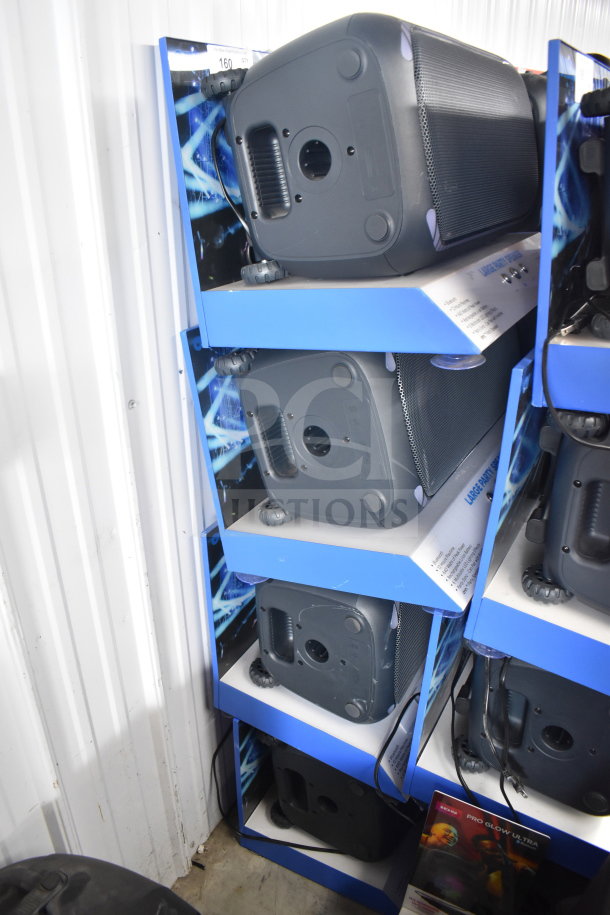 Onn large party speaker display, four units stacked, black with blue accents, wheels for mobility, in-store demo setup.