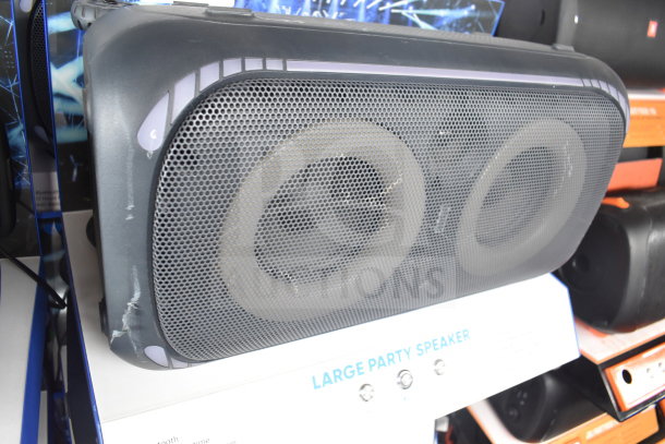 Onn large party speaker on store display, featuring dual drivers and sturdy design. Good condition, promotional label visible.